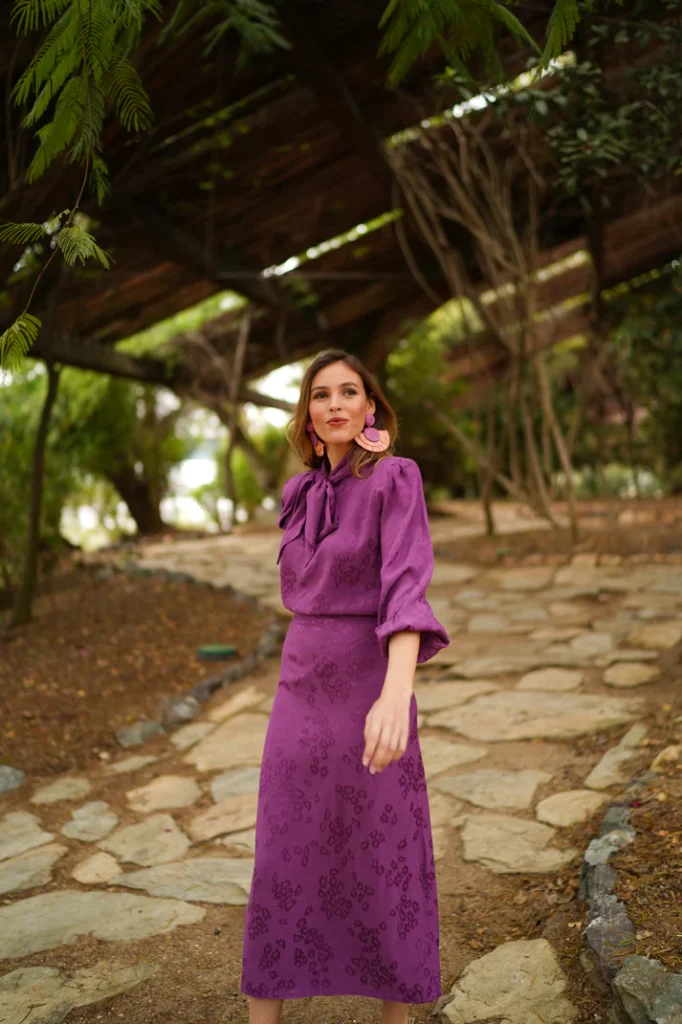Looks de Invitada: conjuntos perfectos para cada ocasión 10 Conjunto de invitada con falda midi y blusa anudada en color malva.